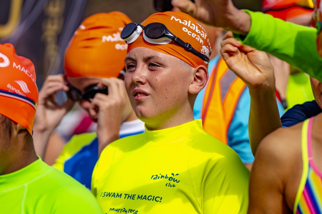 Child in an orange swim cap and yellow rash vest. Drowning Risks for Autistic Individuals: Making a Splash to Prevent Tragedy